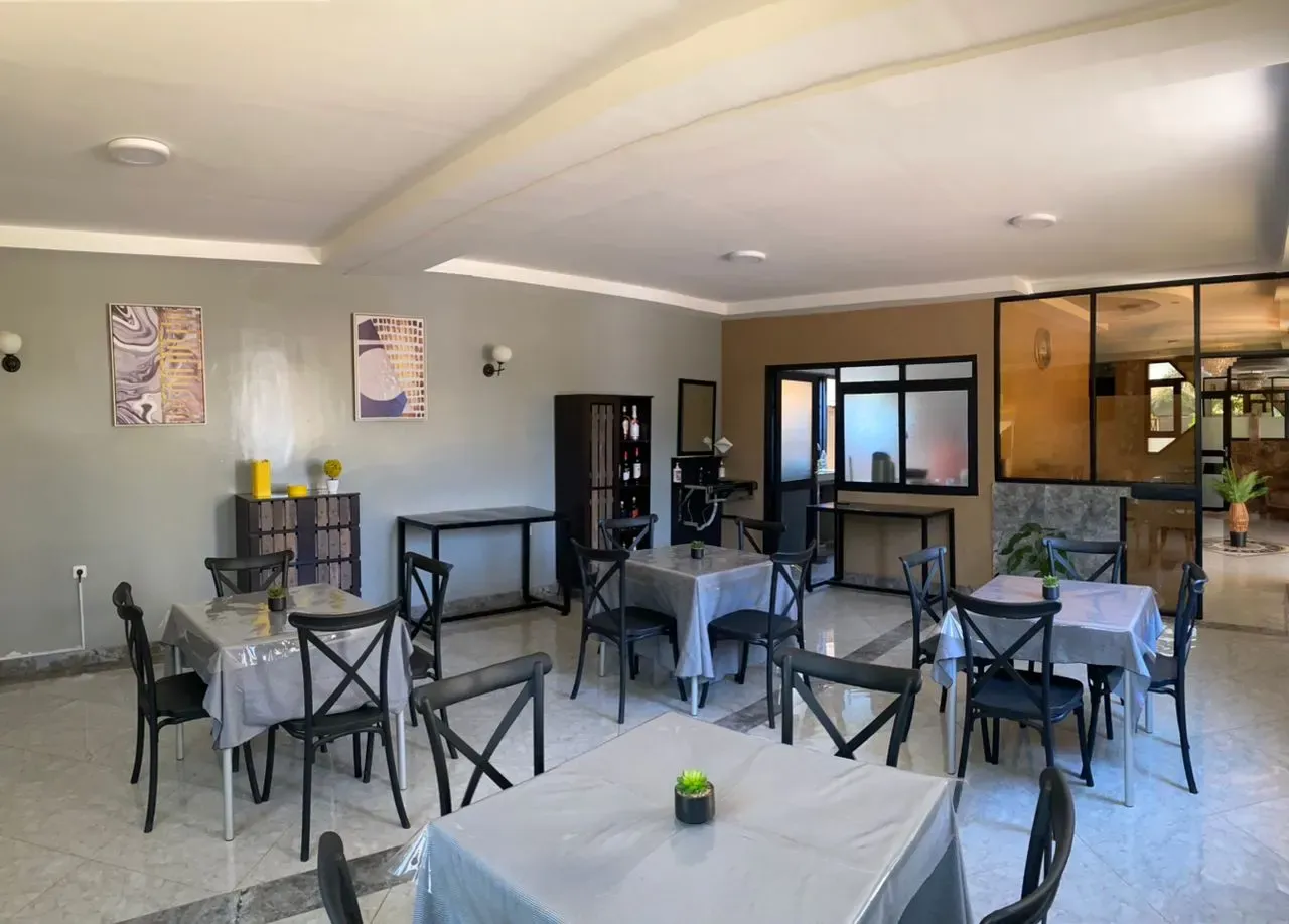 Salle à manger du Vitalo Lodge avec chaises bistrot noires